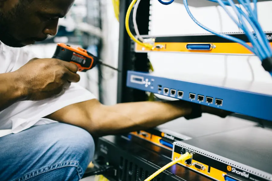 ICT engineer installing network equipment in a rack